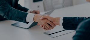 Closeup view of two business professionals making a deal with a handshake